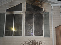 A house window damaged by fire and smoke