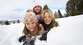 Three children playing in snow