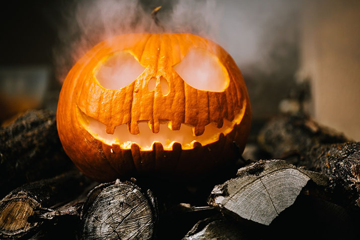 A jack-o-lantern with smoke coming out of it.
