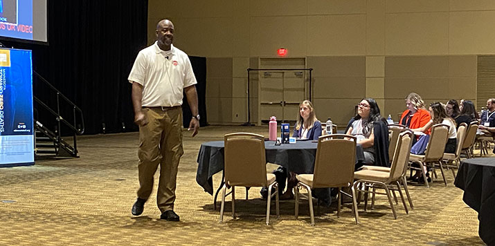 Jermaine Galloway speaking to attendees at a conference.