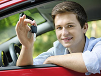 Photo of a teen holding keys while sitting in a car.