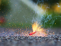 A firecracker burning on the pavement
