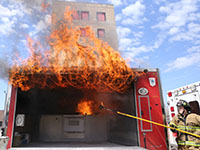 Flames shooting out of a kitchen fire safety trailer during a demonstration