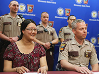 Lisa Jaeger and Col. Matt Langer with three state troopers standing behind them.