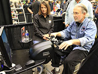 An attendee of the International Motorcycle Show tries out the SMARTrainer at the MMSC booth.
