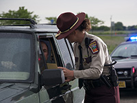 Photo of a state trooper talking to a driver during a traffic stop.
