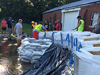 People building a sandbag wall during flooding