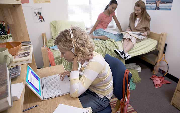 Three students studying in a dorm room