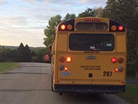 A school bus with flashing red lights and the stop arm extended