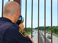an officer checking speeds with a radar gun