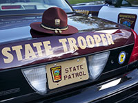 A trooper's hat on the back of a squad car.