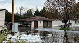 Floodwater and sand bags surrounding a home