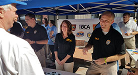 BCA staff members speak with a visitor at the DPS tent during National Night Out