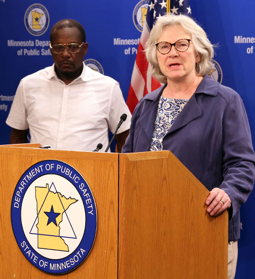 Minnesota Commissioner of Health Jan Malcolm speaking during a news conference. Farji Shaheer is standing in the background. 
