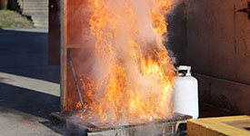 Flames shoot into the air above a turkey fryer during a fire safety demonstration