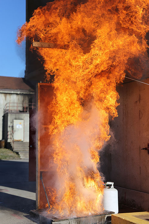 Flames shoot into the air above a turkey fryer during a fire safety demonstration