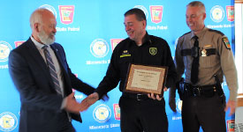 DPS Commissioner Bob Jacobson shakes hands with paramedic Jason Wiskow as Col. Matt Langer watches during the awards ceremony.