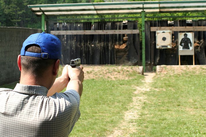 A man shooting a handgun at targets