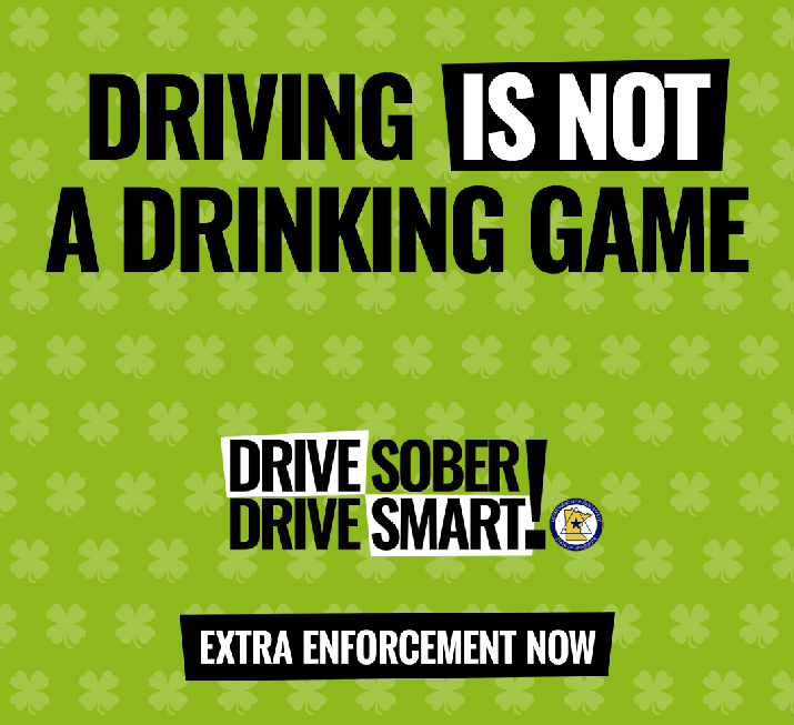 A green, four-leaf clover background with text that says driving is not a drinking game. Drive sober. Drive Smart! Extra Enforcement Now.