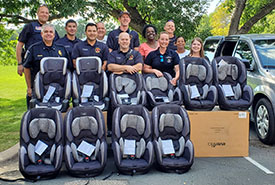 Public employees from St. Louis Park standing behind 10 child car seats.