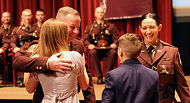 Trooper Tim Vaagenes hugs his children Tuesday after his wife, Trooper Sarah Vaagenes, pinned his badge on his new uniform during the Minnesota State Patrol Academy graduation ceremony.