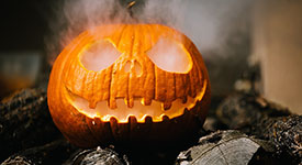 A jack-o-lantern with smoke coming out of it.