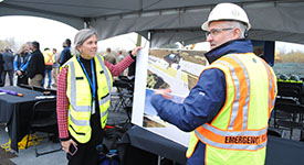 HSEM Director Kristi Rollwagen and Deputy Director Kevin Reed looking at renderings while visiting the site for a groundbreaking event.