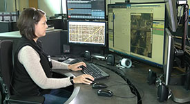 A 911 dispatcher looking at computer screens at a workstation.