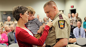 Woman pins new badge on trooper 