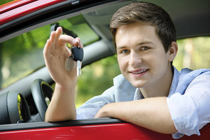 Photo of a teen sitting in a car holding keys.
