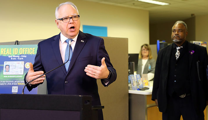 Gov. Tim Walz speaks at a news conference at the new REAL ID office at MSP airport as DPS Commissioner John Harrington looks on