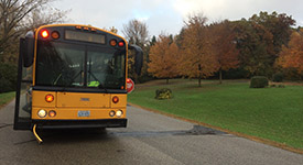 A school bus with lights flashing and the stop arm extended