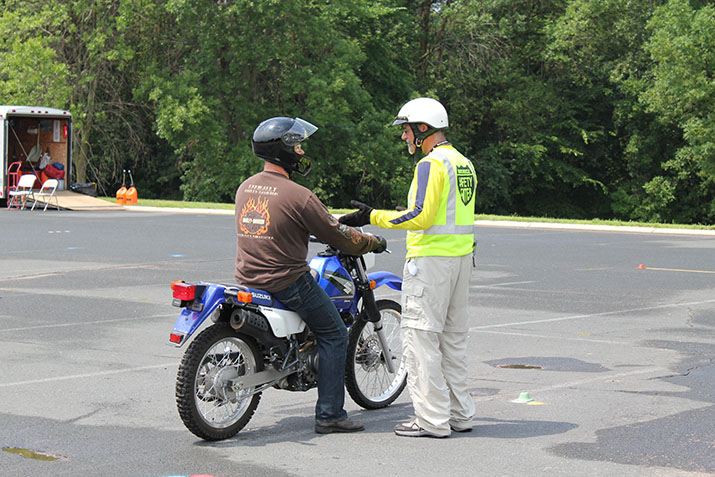 A motorcycle rider talking with a rider training coach