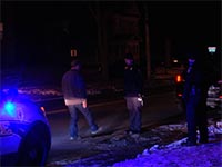 A driver performs a field sobriety test for two officers during a traffic stop