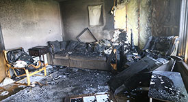 A damaged room in a home after a fire caused by a carelessly discarded cigarette
