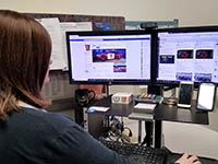 DPS social media coordinator monitoring social media accounts on computer screens