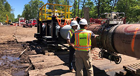 A MNOPS inspector and pipeline worker inspect a horizontal drill rig