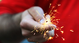 A lit sparkler in a person's hand
