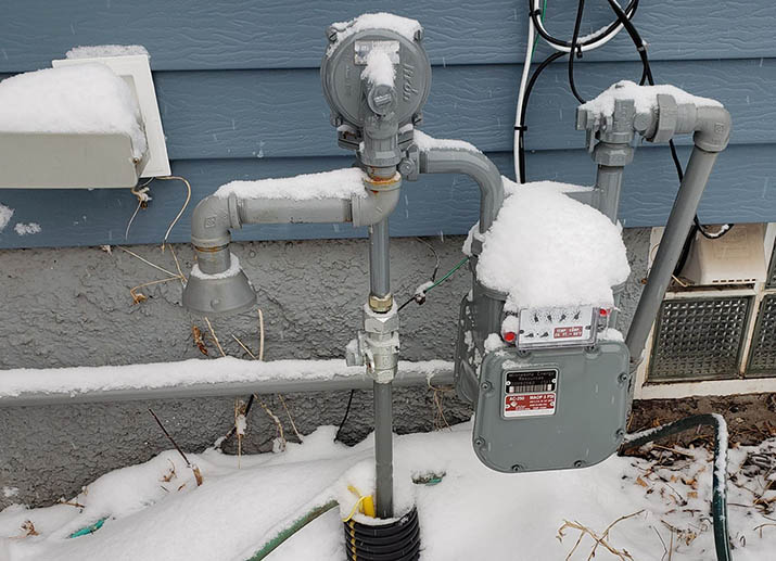 A gas meter with snow on it