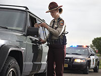 A driver hands a trooper their driver's license.