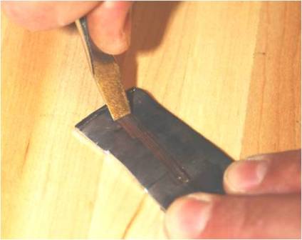 a test mark being made in lead with a screwdriver