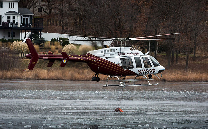 An MSP helicopter scooping up water from a lake