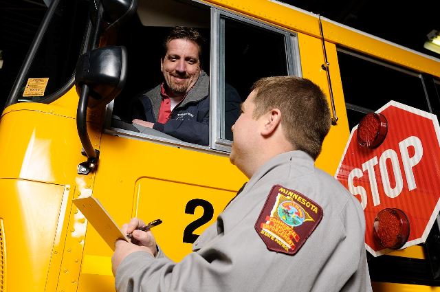 commercial vehicle inspector with the state patrol inspecting a school bus