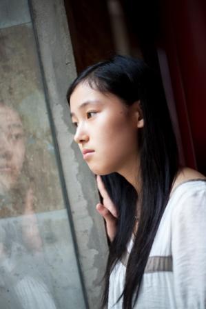 Asian woman looking out window