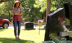 Photo of Cheryl at her sons' grave.