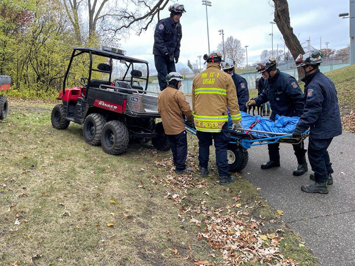 Rescuers carrying an injured person to an emergency vehicle