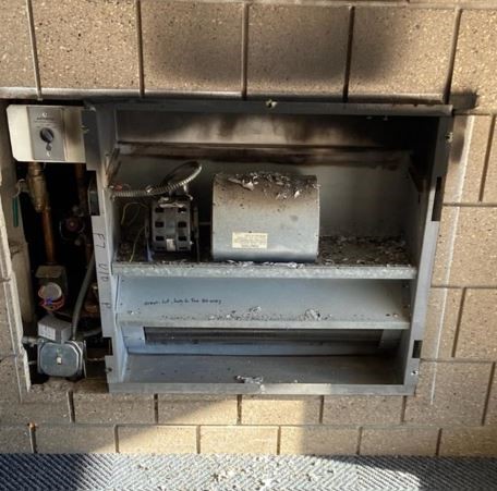 A damaged vestibule heating unit at a school