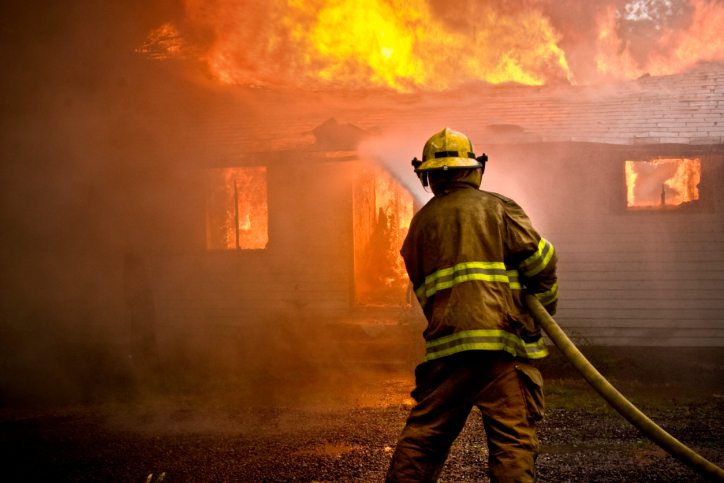 Firefighter battling a blaze with a hose