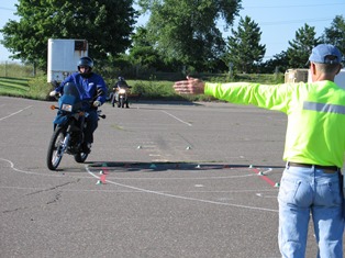 motorcycle safety instructor showing trainee a hazard avoidance technique