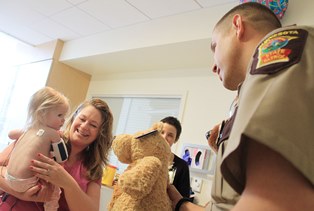State Trooper visiting a sick child at the Amplatz Children's Hospital